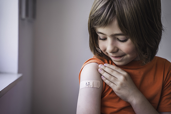 接种疫苗后看手臂创可贴的女孩