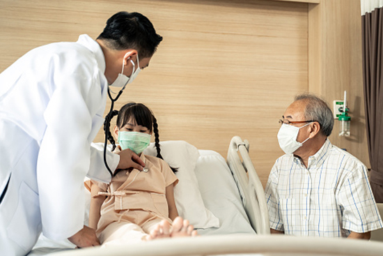 Doctor checking girl in hosptial bed