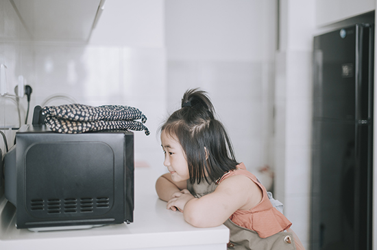 Child looking at microwave