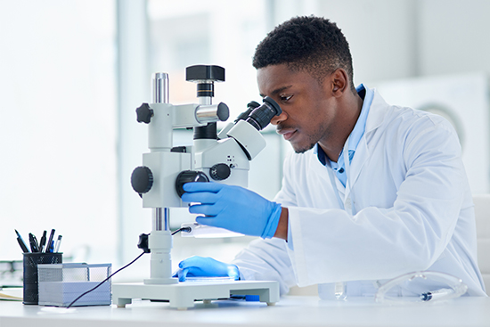 Scientist looking through his microscope.