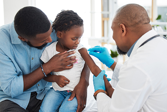 Boy getting vaccine in arm.