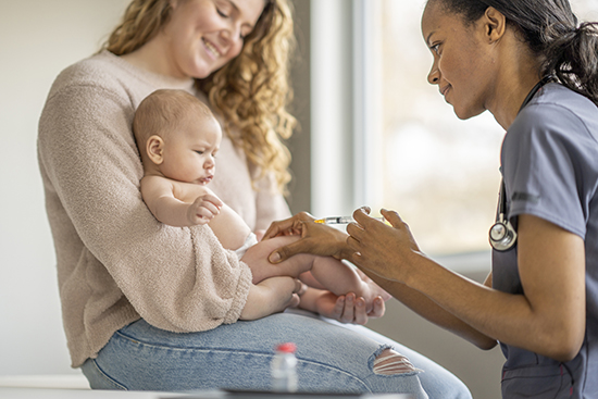 Infant getting vaccine in leg.