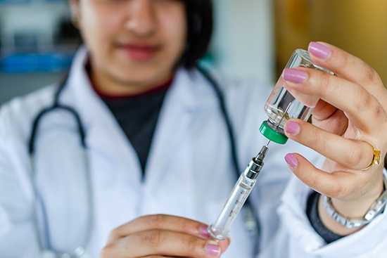 Doctor with syringe and vial.