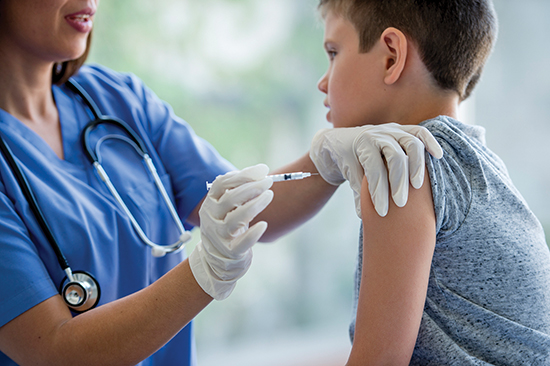 Child receiving a vaccine in the upper arm. 