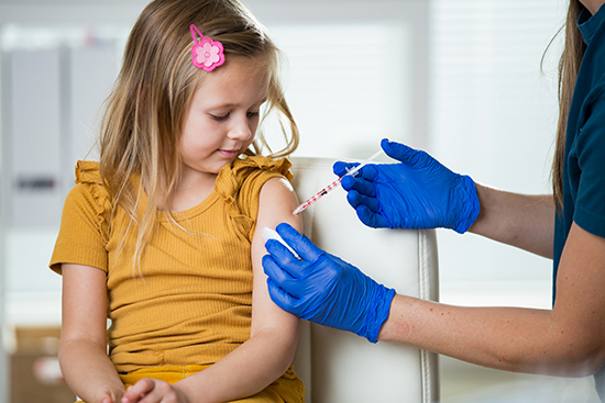 Girl getting vaccine in arm.