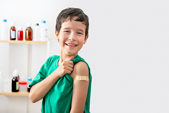 Boy with bandaid on arm after getting a vaccine.